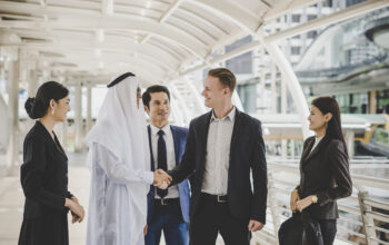Portrait of business partners greeting one another by handshaking on the way to office.